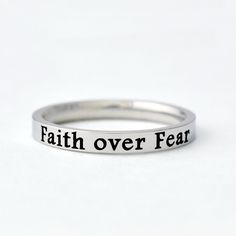 "This listing is for one stainless steel band ring, engraved with \"Faith over Fear\" on the outside.  It makes a best gift for friends, sisters in Christ or yourself. Always be reminded to embrace faith over fear. Materials & Features: This ring is made of high quality hand polished solid stainless steel, which is hypoallergenic (good for metal-sensitive skin). Stainless steel will not tarnish, its luster and durability will make it last for many years. The black text on the ring will not fade Her And Him, Friend Bff, Quote Inspirational, Stacking Bands, Wide Ring, Fade Out, Faith Over Fear, Christian Jewelry, Tiny Heart