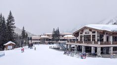 people are skiing in the snow outside of a building