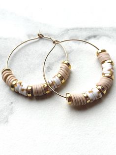 White Heishi Earrings| Gold Hoop  Earrings| Lightweight| Nickel Free| Birthday Gift| Minimalist Jewelry| Everyday Jewelry  Color: White and Tan with Gold Spacer Beads Daniela Dawsyn Design Earrings are uniquely made. Heishi hoop earrings are lightweight and nickel free.  They are handcrafted and should be handled with care. Do not bend. Do not wear in water.  Daniela Dawsyn Design pull boxes and Daniela Dawsyn Design suede cases are available for purchase to store your earrings in when traveling Everyday White Jewelry With Dangling Beads, White Small Hoop Beaded Earrings Nickel Free, Everyday Round White Beaded Earrings, Nickel Free White Circle Hoop Earrings, White Everyday Earrings With Colorful Beads, Everyday White Earrings With Colorful Beads, White Beaded Earrings With Dangling Beads For Everyday, Everyday White Beaded Earrings With Dangling Beads, Everyday White Round Beaded Earrings