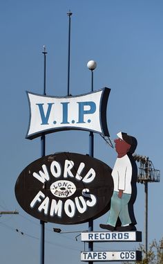 a large sign that says world famous with a man painting the sign on it's side