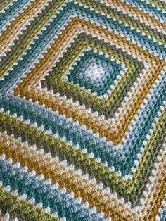 a crocheted blanket that is on top of a table