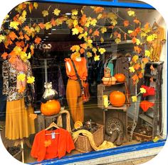 a window display with orange and yellow leaves