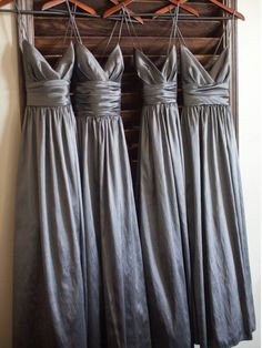 four bridesmaid dresses hanging on a rack