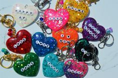 many different colored heart shaped key chains on a marble surface with the words happy valentine's day written on them