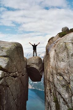 a man standing on top of a large rock formation