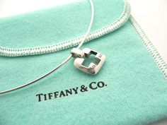 Offered for sale is a beautiful and rare Tiffany & Co. Cross stencil / cut out necklace. Very pretty and unique Tiffany piece that you will get your money's value for. The necklace works perfectly with pretty much any attire your put on, AND is sure to be a conversation starter! It is the perfect piece for a lifestyle on the go -- can be worn to pretty much any occasion! It is simple, elegant, and classic all rolled into one item. Imagine wearing the necklace with your office attire... now imagi Designer Engraved Necklace For Gift, Designer Sterling Silver Necklace Gift, Designer Sterling Silver Necklace For Gift, Sterling Silver Necklace With Logo Charm, Cross Stencil, Bvlgari Necklace, Solitaire Diamond Pendant, Rare Gifts, Solitaire Pendant Necklace