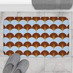 a pair of feet are standing in front of a bath mat with an art deco fan pattern on it