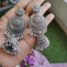 Elevate your jewelry collection with these stunning Oxidized Silver Jhumka Earrings, inspired by traditional Kashmiri craftsmanship. Handcrafted with meticulous attention to detail, these earrings feature intricate floral motifs and exquisite filigree work that perfectly captures the essence of Indian heritage. The large circular design is complemented by delicate ghungroo bells, adding a playful jingle with every movement. Ideal for festive occasions, weddings, and casual outings, these stateme Metal Jhumkas For Festival, Pierced Ears, Metal Jhumkas For Pierced Ears For Festival, Bohemian Festive Jhumkas, Festive Bohemian Jhumkas, Temple Jewelry Festival Earrings With Latkans, Bohemian Drop Jhumkas For Festivals, Bohemian Jhumkas With Intricate Design, Bohemian Jhumkas With Latkans For Gift, Bohemian Jhumkas With Latkans As Gift