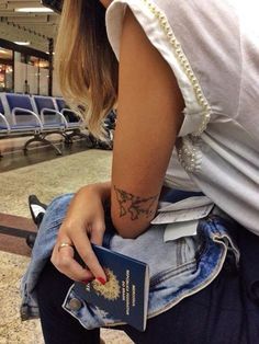 a woman with a tattoo on her arm holding a book