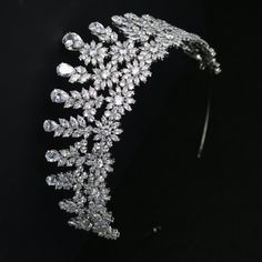 Floral CZ Bridal Tiara This stunning cz tiara will add a regal look to your wedding or quinceanera ensemble. The brilliant round, marquise and teardrop cz crystals are beautifully arranged in a multi peak floral design that will be perfect for your special day. The silver plated ear to ear design design glistens with high quality cz crystals, providing sparkle from every angle. A gorgeous headpiece for your wedding or quinceanera! Color: Silver/Clear. Style: hp7597. Size: Design is about 2 1/3" Beaded Edge Veil, Winter Wedding Accessories, Beaded Wedding Veils, Quinceanera Tiaras, Hand Jewelry Rings, Crystal Wedding Tiaras, Rose Gold Tiara, Veil Accessories, Crystal Bridal Tiaras