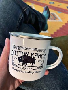 a person holding a white coffee mug in their left hand with the words fulton ranch on it