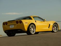 a yellow sports car driving down the road