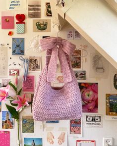 a purse is hanging on the wall with pictures and magnets all over it's surface