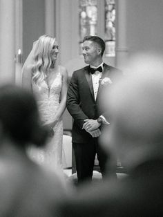 a bride and groom standing in front of the alter at their wedding ceremony, looking into each other's eyes