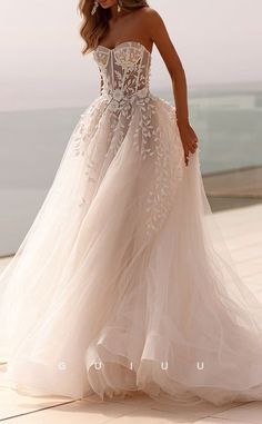 a woman in a wedding dress standing on the beach