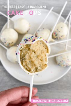 cake pops with sprinkles are on a white plate and there is a hand holding one