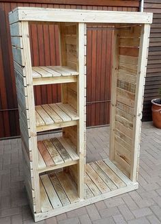 a wooden shelf sitting on top of a brick floor next to a potted plant