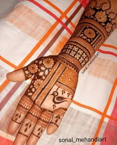 the hand is decorated with henna designs on it's fingers and hands,