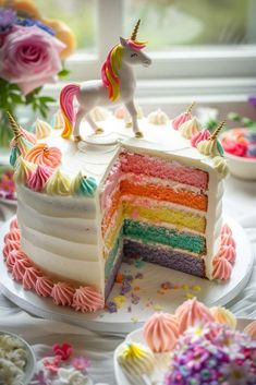 a rainbow cake with a unicorn on top