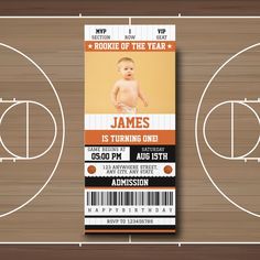 a basketball court with a ticket card for a baby's first birthday on it