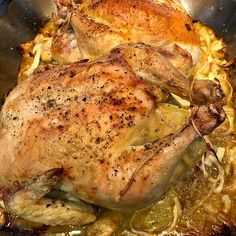 a roasted chicken in a pan with onions