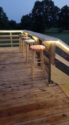 several stools are lined up on a wooden deck