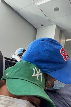 a man wearing a new york yankees baseball cap and mask in an airport waiting area