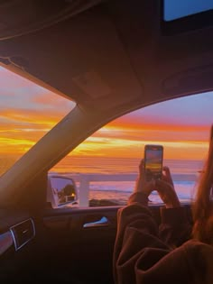 a woman sitting in the back seat of a car while looking at her cell phone