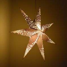 a star shaped light hanging from a ceiling