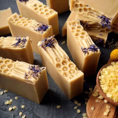 several soap bars with lavender on them next to a wooden spoon