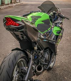 a green and black motorcycle parked on the street