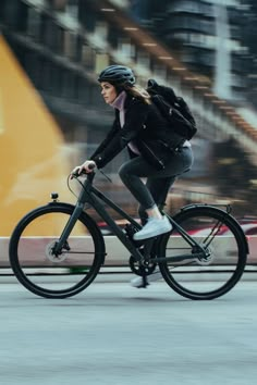 a woman is riding her bike down the street