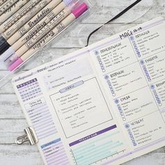 a planner with markers and pencils next to it