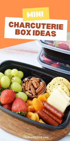 a bento box filled with fruit, crackers and cheese on top of it