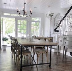 a dining room table with six chairs and a chandelier hanging from the ceiling