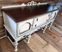 a white and brown dresser sitting on top of a wooden floor