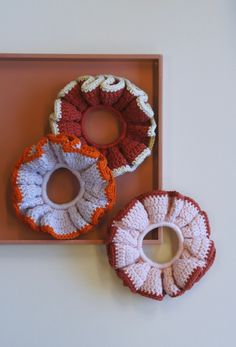 three crocheted donuts sitting on top of a tray