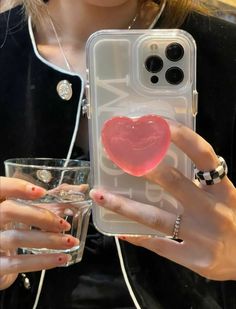 a woman holding up a phone case with a heart on it