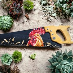 a pair of scissors sitting on top of a table next to succulents