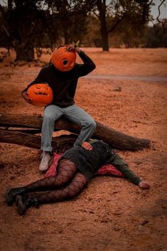 a man laying on the ground next to a woman in fish net stockings holding an orange pumpkin