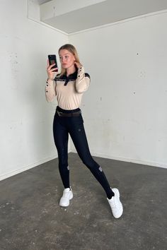 a young woman is taking a selfie with her cell phone in an empty room