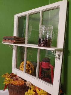 an old window is decorated with fall leaves and other things to decorate in the windowsill