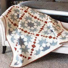 a quilted blanket sitting on top of a white chair