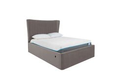 an upholstered bed frame with a mattress on the bottom and two pillows on top