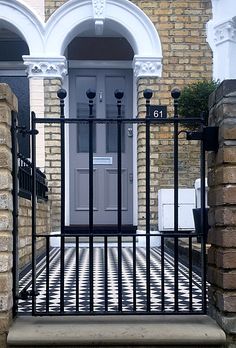 an iron gate is in front of a brick building