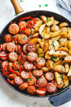 sausage and potatoes in a skillet with parsley on the side, ready to be eaten