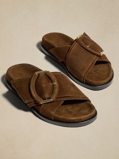 An instant way to elevate any outfit, reach for these luxurious suede slides when comfort calls.  Crafted in Italy with a molded footbed for added support, these slide sandals are finished with our signature demi-lune buckle in an oversized proportio Suede Footbed Sandals With Tang Buckle And Round Toe, Suede Slide Sandals With Buckle Closure, Brown Suede Sandals With Tang Buckle, Suede Slides With Buckle Closure And Round Toe, Brown Suede Slides With Buckle Closure, Spring Suede Slides With Buckle Closure, Suede Slides With Leather Footbed, Suede Slide Footbed Sandals, Suede Slides With Cushioned Footbed