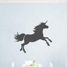 a black unicorn wall decal in a child's room with a table and chairs