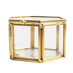 a small glass box with gold trimmings on the top and bottom, sitting in front of a white background