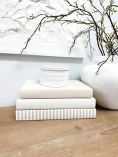 two white vases sitting next to each other on top of a wooden table